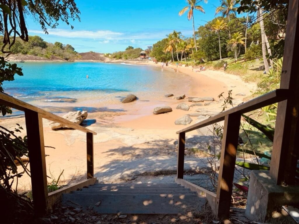 Vista aérea das praias de Guarapari com água verde-esmeralda e montanhas ao fundo
